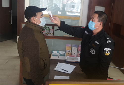 图为工作人员正在进行体温监测